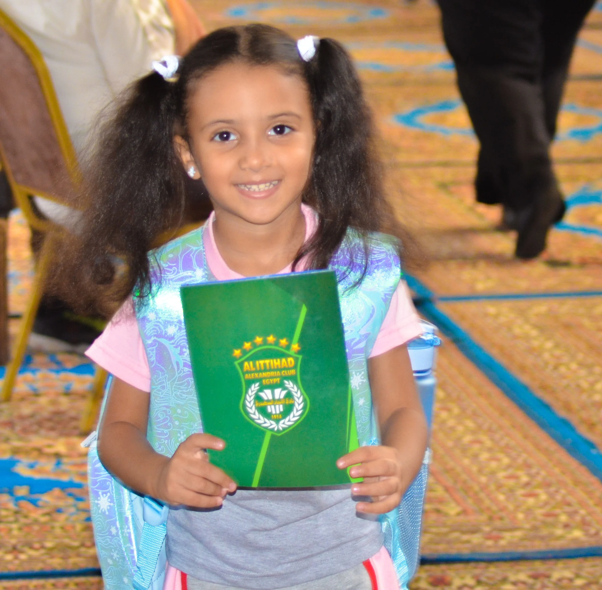 طفلة تحمل كراسة اللائحة الجديدة